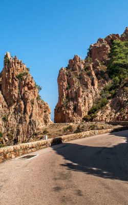 a road in the middle between two rocks on the island of corsica