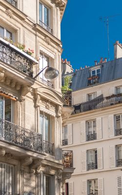 haussmannian style buildings in paris, france, against blue sky.